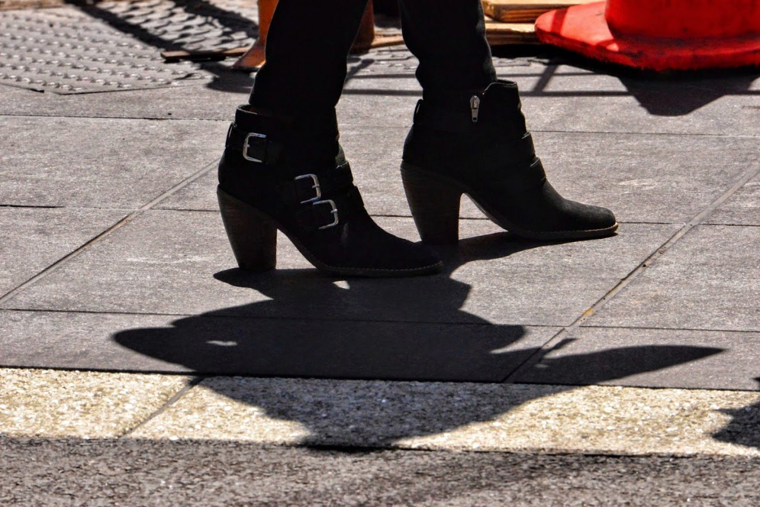 Boots and shadow on sidewalk